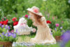 Girl with white puppy in flower garden