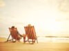 Couple holding hands on beach at sunset